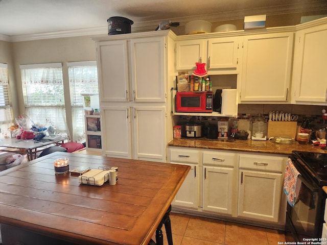 kitchen featuring crown molding, light tile patterned floors, black electric range, and white cabinets