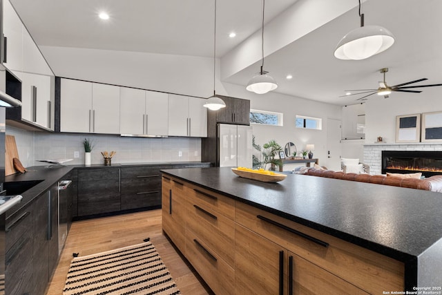 kitchen featuring white cabinetry, backsplash, hanging light fixtures, white fridge, and ceiling fan