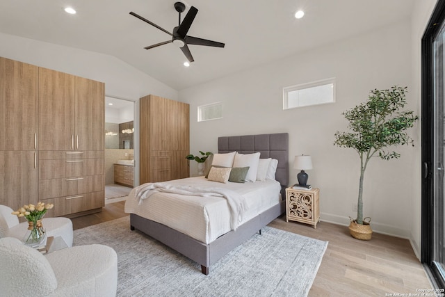 bedroom featuring ceiling fan, connected bathroom, vaulted ceiling, and light wood-type flooring