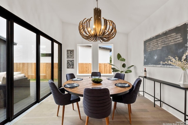 dining room featuring lofted ceiling, a notable chandelier, and hardwood / wood-style flooring