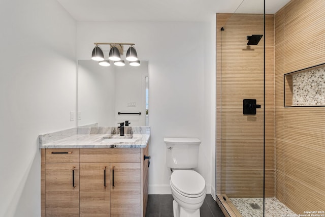 bathroom with tile patterned flooring, vanity, a tile shower, and toilet