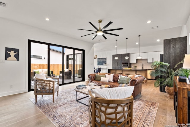 living room featuring ceiling fan and light hardwood / wood-style floors