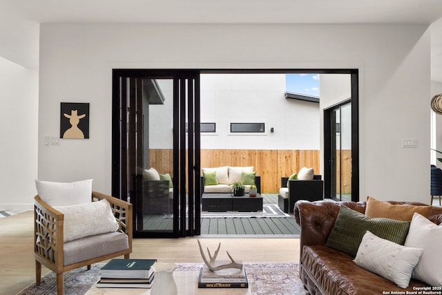 living room with wooden walls and light hardwood / wood-style flooring