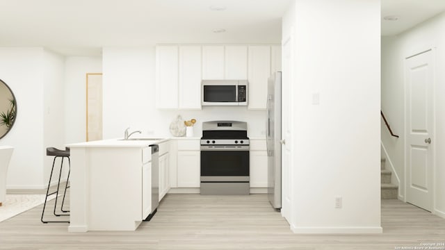 kitchen with stainless steel appliances, kitchen peninsula, light wood-type flooring, and white cabinets