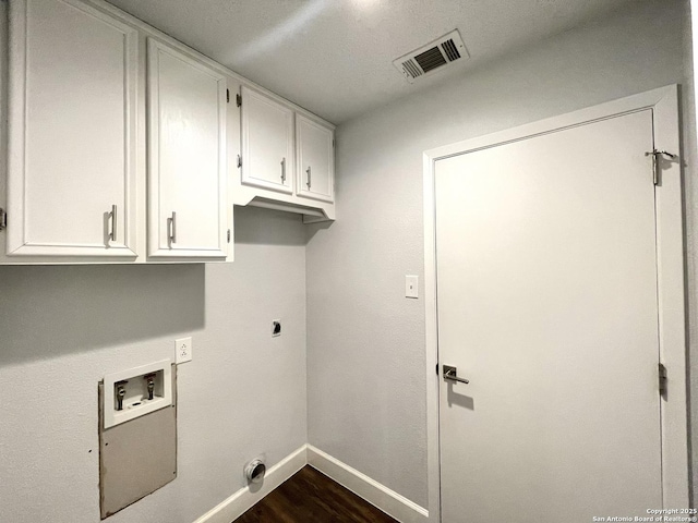 clothes washing area featuring electric dryer hookup, hookup for a washing machine, dark hardwood / wood-style flooring, and cabinets