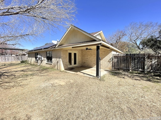 back of house featuring french doors, a patio area, and solar panels