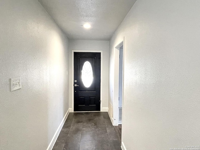 doorway with a textured ceiling