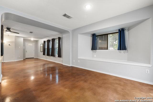 empty room with ceiling fan and concrete flooring