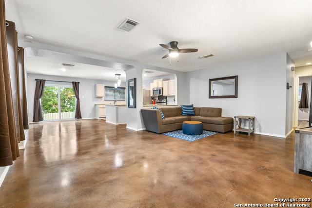 living room with concrete floors and ceiling fan