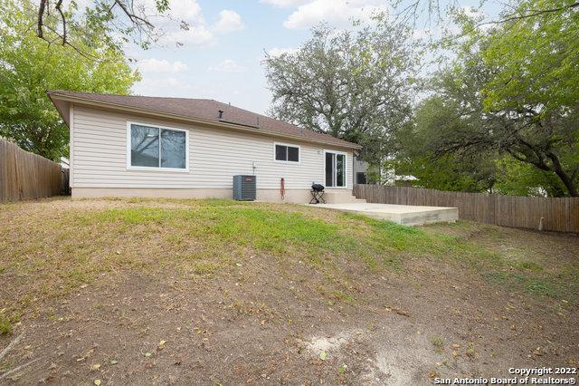 rear view of property with a yard, cooling unit, and a patio area