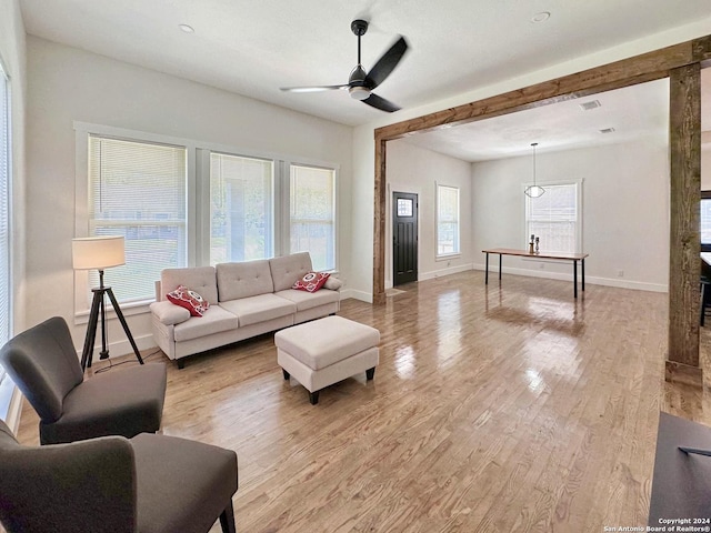 living room with ceiling fan, a healthy amount of sunlight, and light wood-type flooring