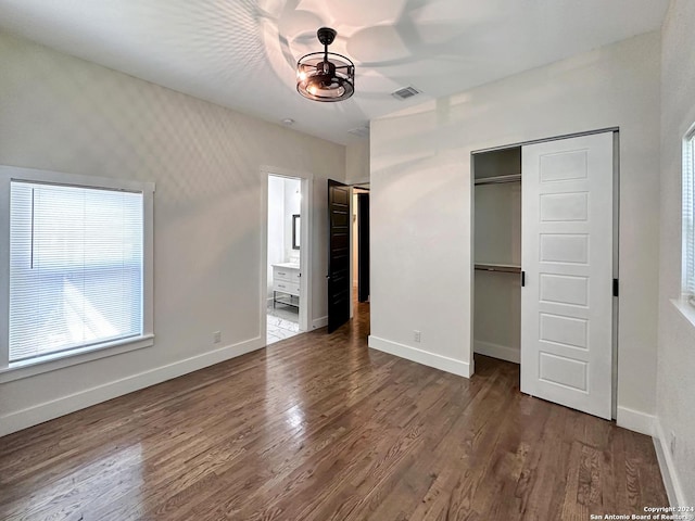 unfurnished bedroom featuring ceiling fan, ensuite bath, and dark hardwood / wood-style flooring