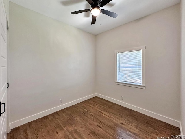 empty room with ceiling fan and dark hardwood / wood-style flooring