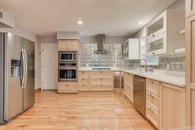 kitchen featuring sink, extractor fan, tasteful backsplash, light hardwood / wood-style flooring, and appliances with stainless steel finishes