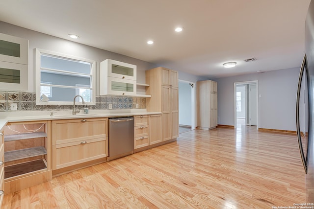 kitchen featuring dishwasher, sink, light brown cabinetry, and decorative backsplash