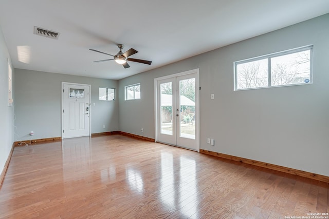 spare room with french doors, ceiling fan, and light wood-type flooring