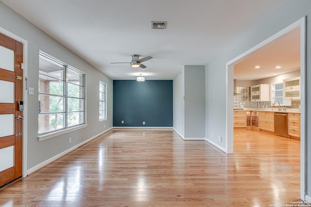 spare room with sink, ceiling fan, and light wood-type flooring