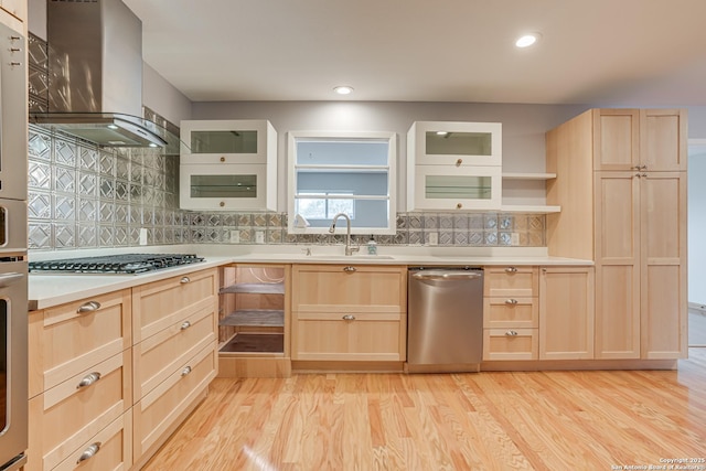 kitchen featuring sink, range hood, stainless steel appliances, light brown cabinetry, and light wood-type flooring