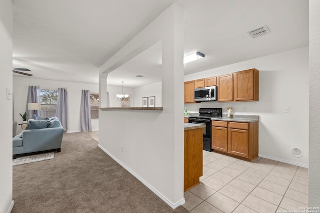 kitchen featuring a chandelier, black electric range, kitchen peninsula, pendant lighting, and light colored carpet