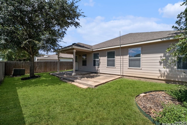 rear view of house featuring a lawn and a patio