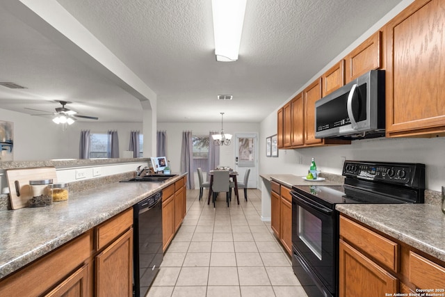 kitchen with light tile patterned floors, sink, hanging light fixtures, black appliances, and a textured ceiling