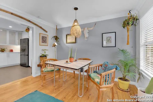 dining room featuring crown molding and light hardwood / wood-style flooring