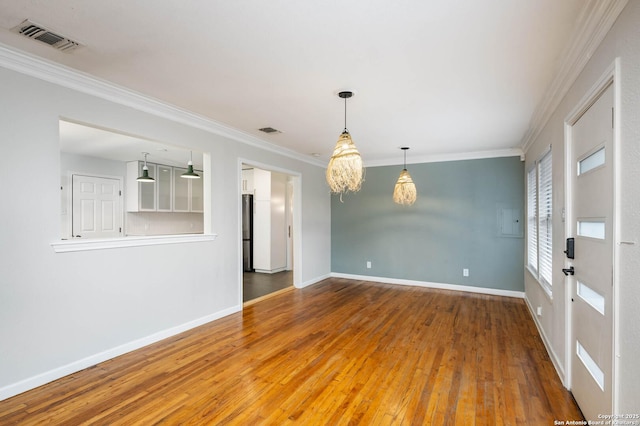 empty room featuring hardwood / wood-style flooring and crown molding