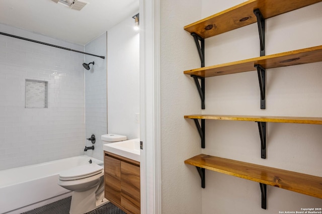 full bathroom with vanity, tiled shower / bath, and toilet