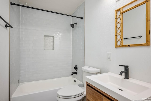 full bathroom featuring vanity, tiled shower / bath, and toilet