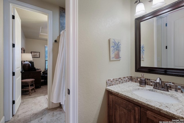 bathroom featuring vanity and backsplash