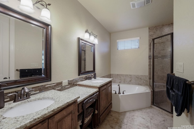 bathroom with vanity, tasteful backsplash, and independent shower and bath