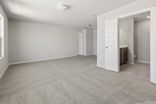 unfurnished room with light carpet, light tile patterned floors, baseboards, and visible vents