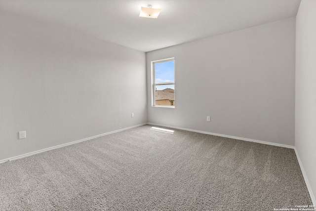 empty room with carpet and baseboards