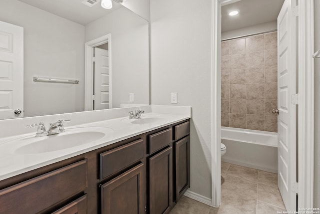 bathroom with toilet, tile patterned flooring, double vanity, and a sink