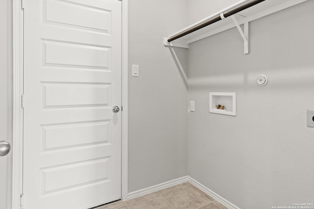 laundry area with laundry area, light tile patterned floors, baseboards, hookup for a washing machine, and electric dryer hookup