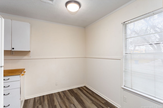 unfurnished room featuring crown molding, dark hardwood / wood-style floors, and a textured ceiling