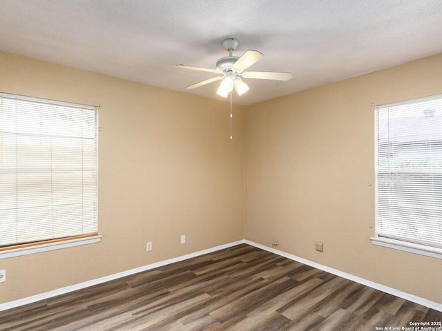 empty room featuring ceiling fan, dark hardwood / wood-style floors, and a healthy amount of sunlight