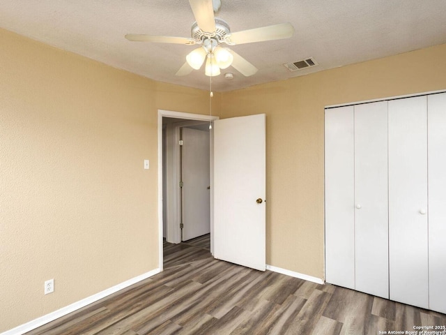 unfurnished bedroom featuring hardwood / wood-style flooring, ceiling fan, and a closet