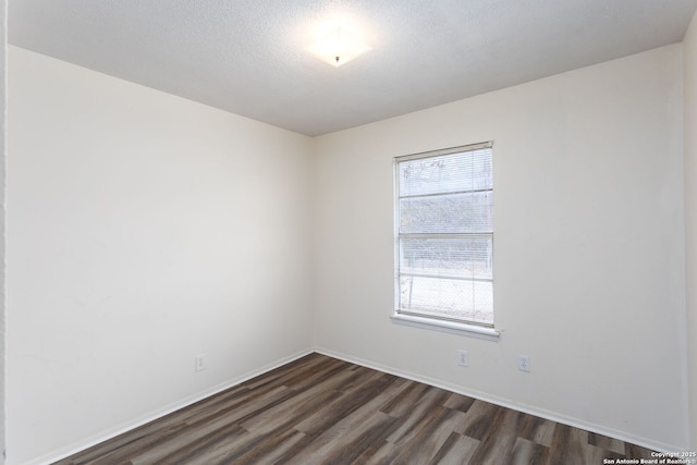 unfurnished room featuring dark hardwood / wood-style flooring and a textured ceiling