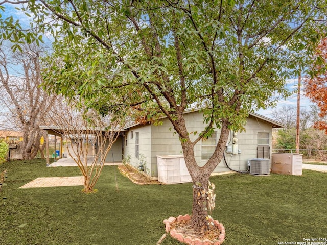 view of side of property with a yard, cooling unit, and a patio area