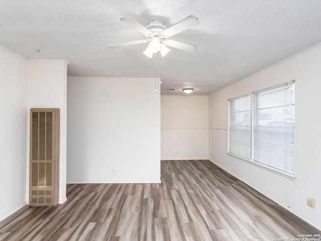 empty room with ceiling fan, hardwood / wood-style flooring, ornamental molding, and a textured ceiling