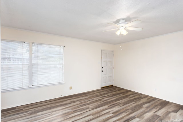 empty room featuring ornamental molding, a healthy amount of sunlight, and hardwood / wood-style floors