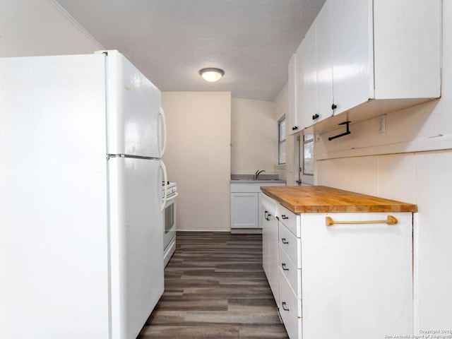 kitchen featuring wood counters, sink, white cabinetry, a textured ceiling, and white appliances