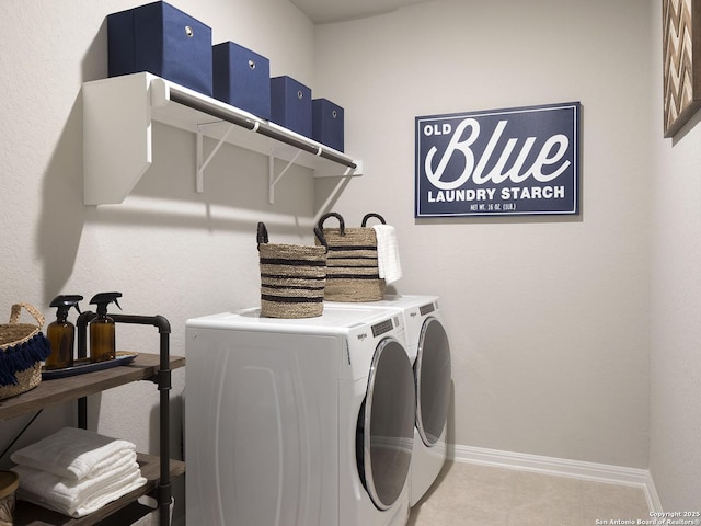 laundry area with laundry area, washing machine and dryer, and baseboards