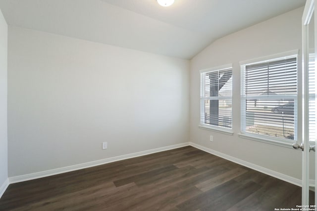 empty room with vaulted ceiling, baseboards, and dark wood-style flooring