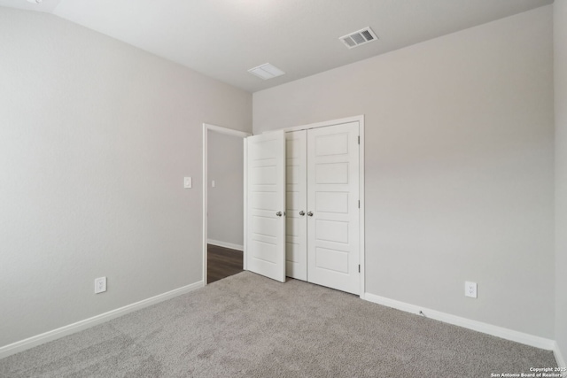 unfurnished bedroom with carpet, visible vents, a closet, and baseboards