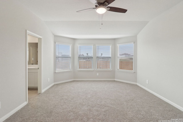 unfurnished room featuring a ceiling fan, vaulted ceiling, carpet, and baseboards