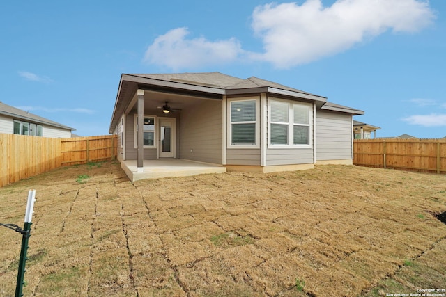 rear view of property with a fenced backyard, a ceiling fan, and a patio area