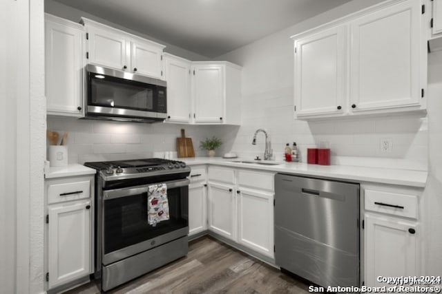 kitchen with tasteful backsplash, appliances with stainless steel finishes, and white cabinets