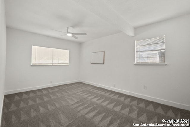 unfurnished room featuring beamed ceiling, ceiling fan, and dark carpet